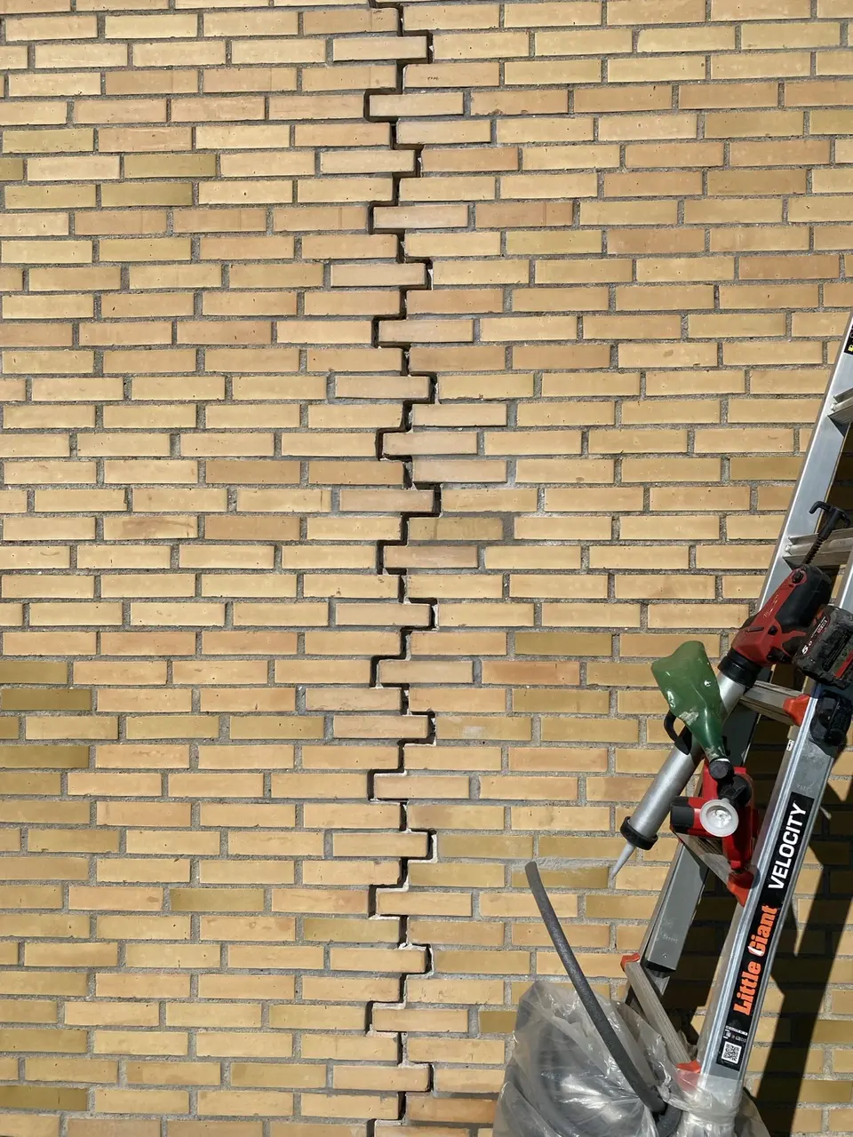 Førbillede af åben fuge gennem gul murstensfacade på Amager